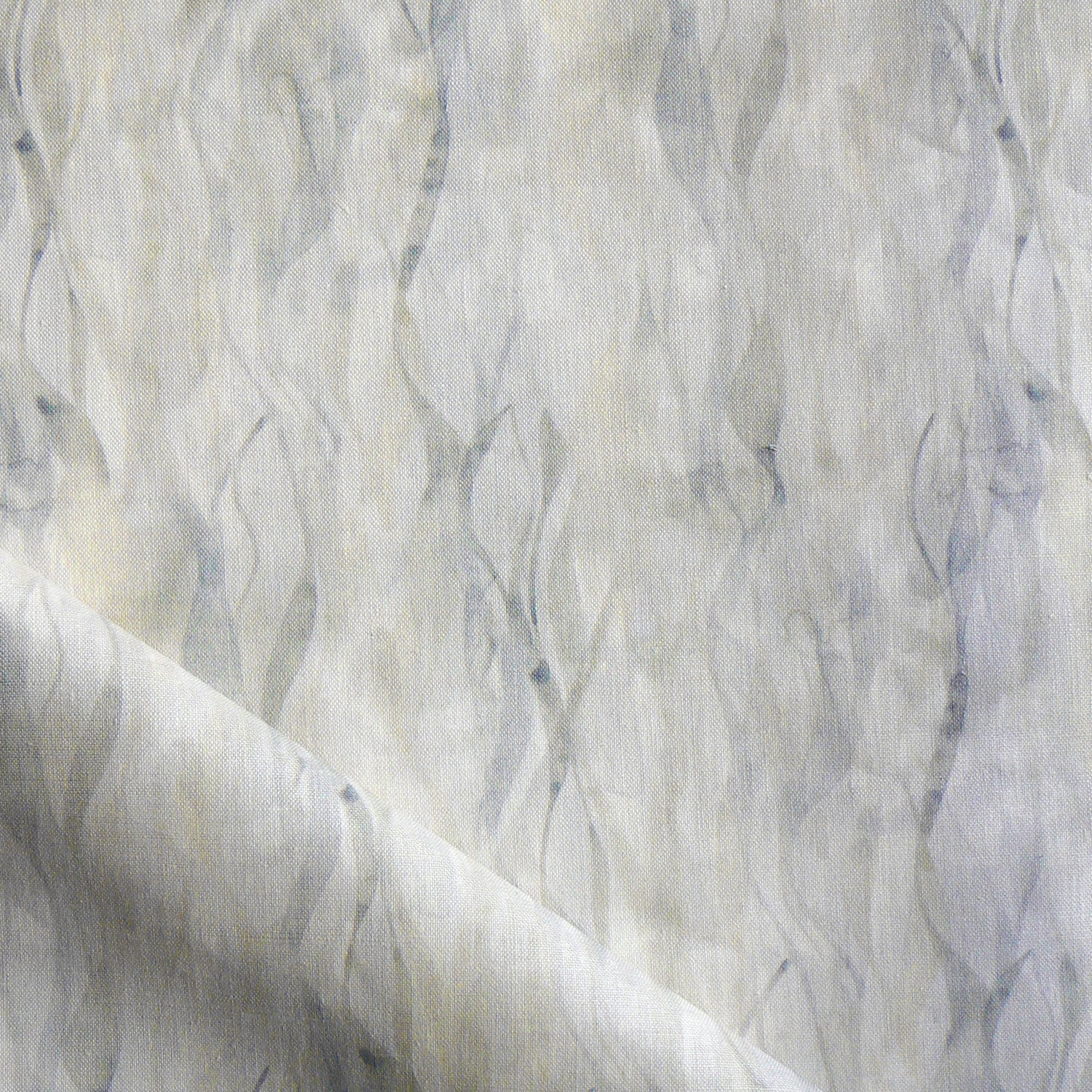 Draped fabric in a layered squiggle watercolor pattern in shades of grey and warn tan, 