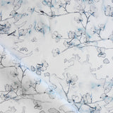 Draped fabric in a watercolor branch and floral pattern in shades of blue on a white field.