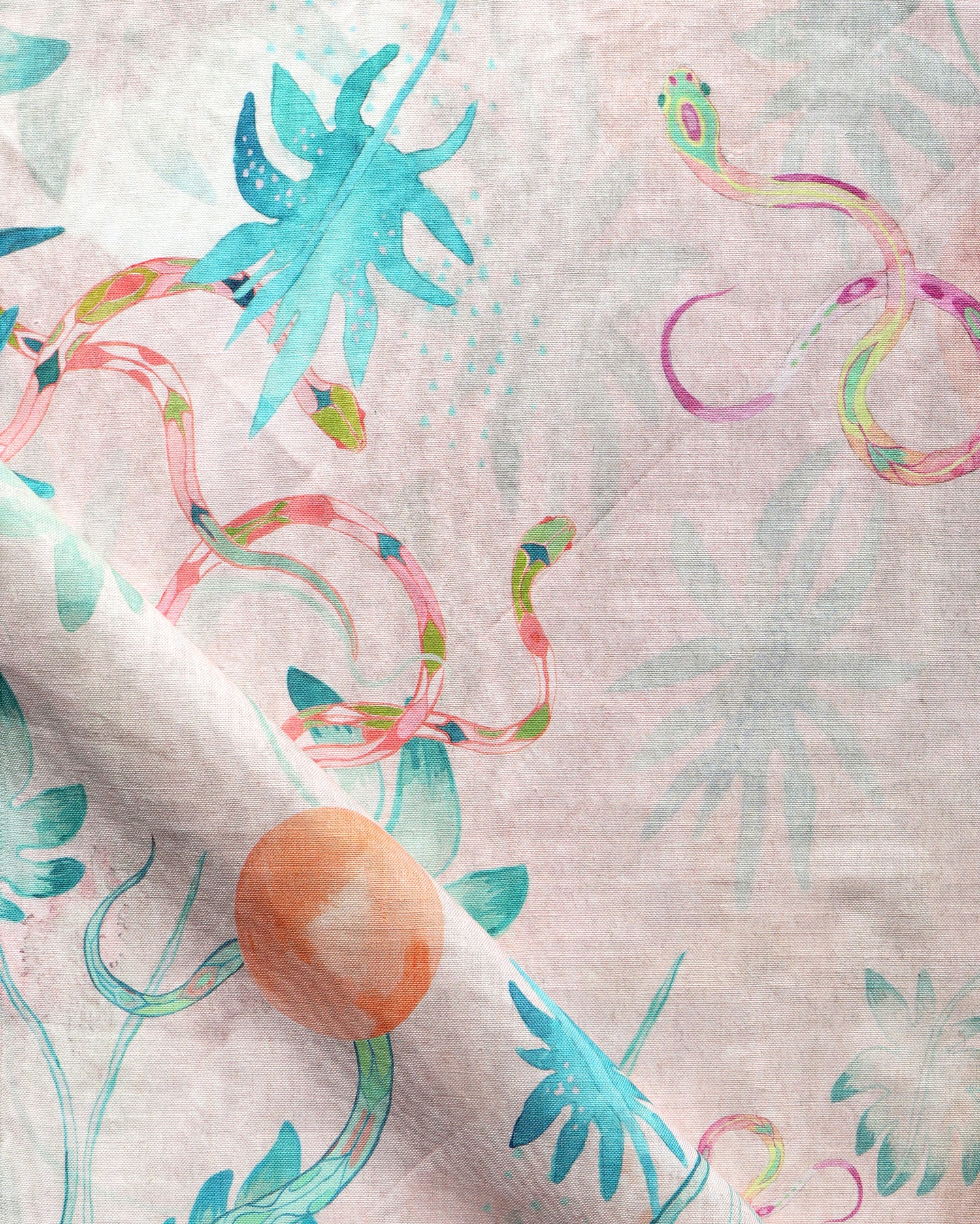 Detail of draped fabric in a playful leaf and snake print in turquoise, pink and green on a coral field.