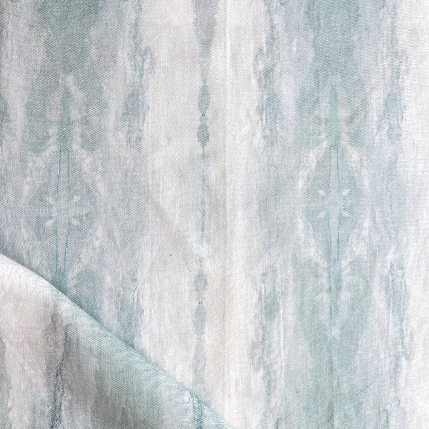 Detail of draped fabric in a watercolor textural print in shades of gray and blue-gray.