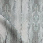 Detail of draped fabric in a watercolor textural print in shades of gray.