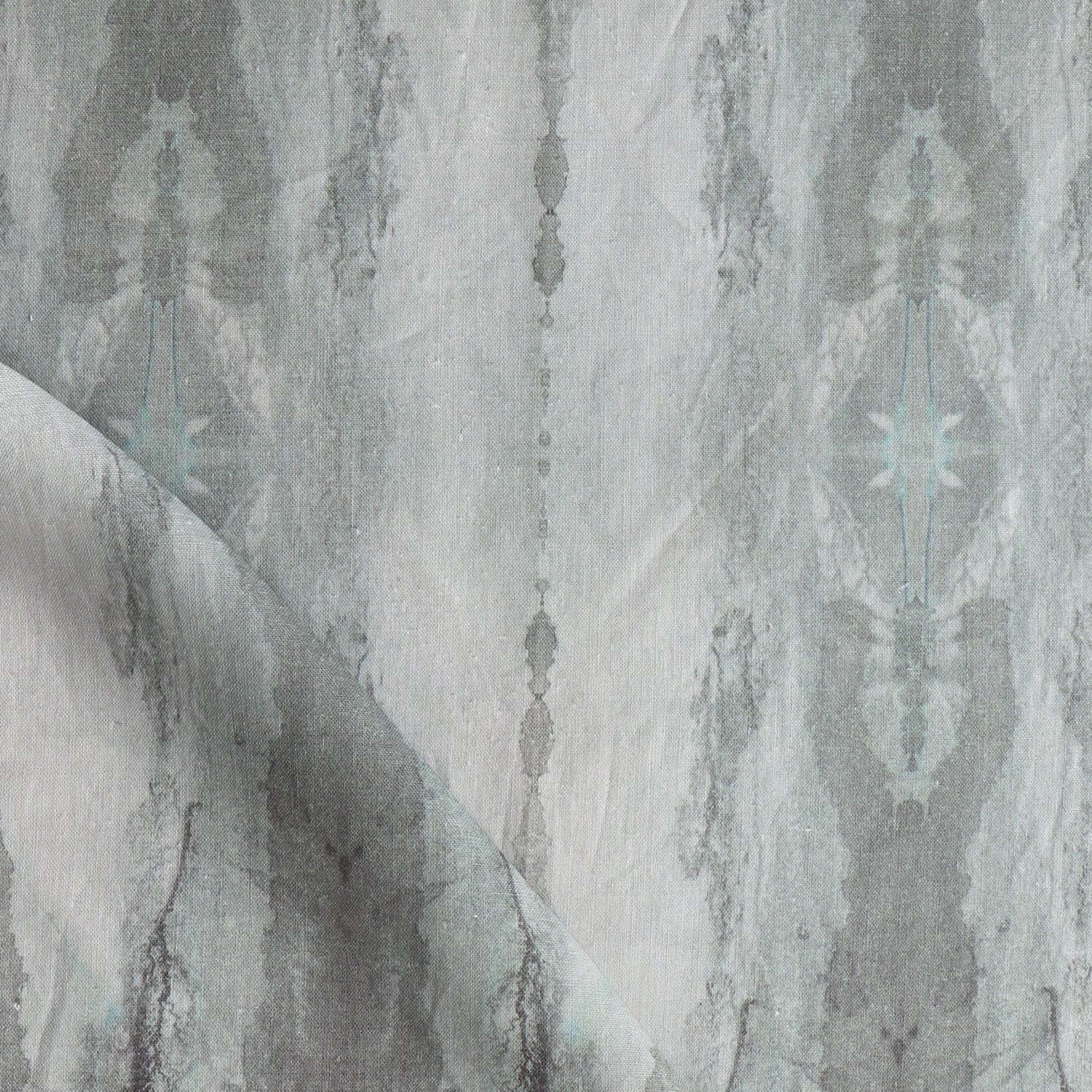 Detail of draped fabric in a watercolor textural print in shades of gray.