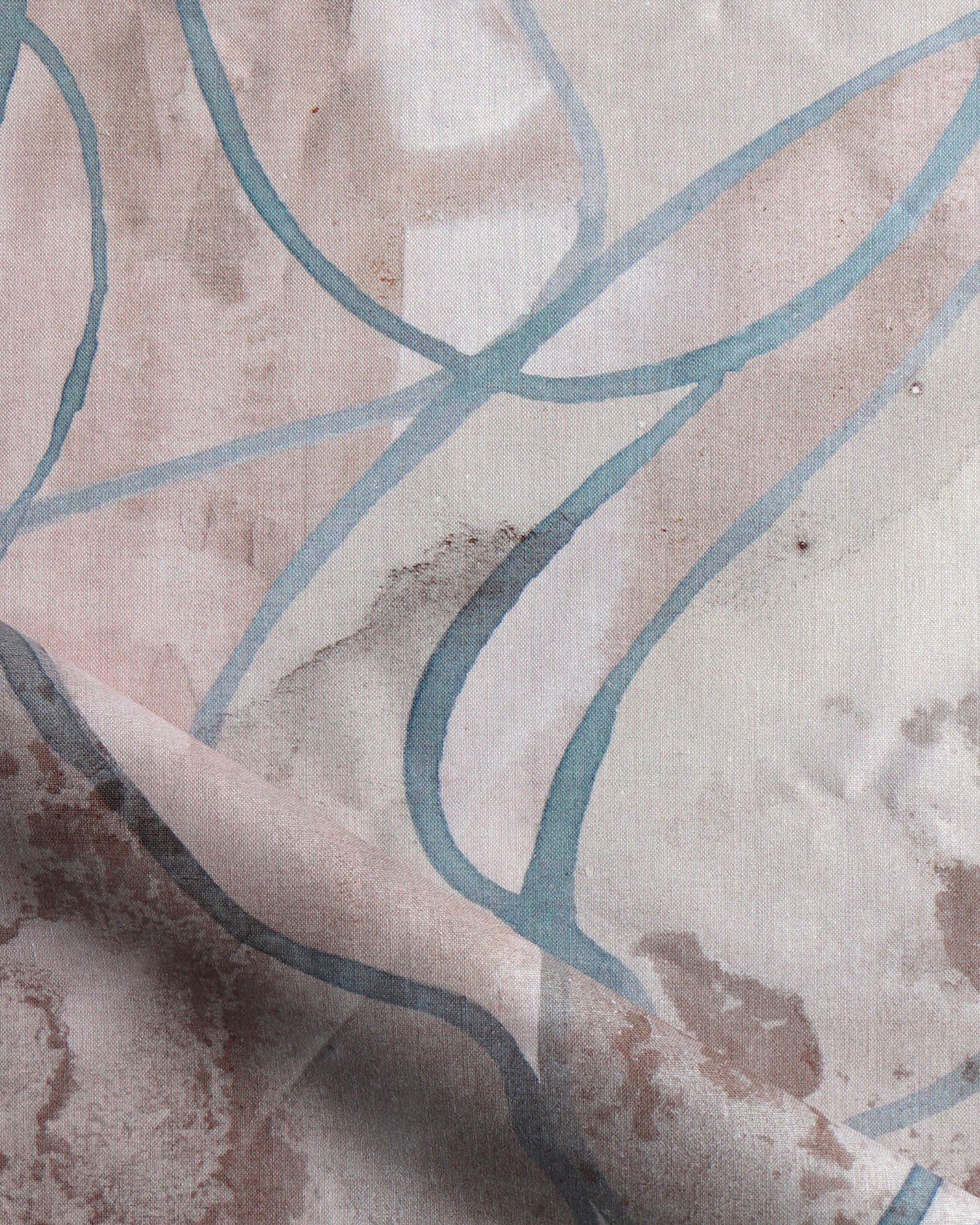 Draped fabric in abstract floral bushstroke design in warm mauve with teal. 