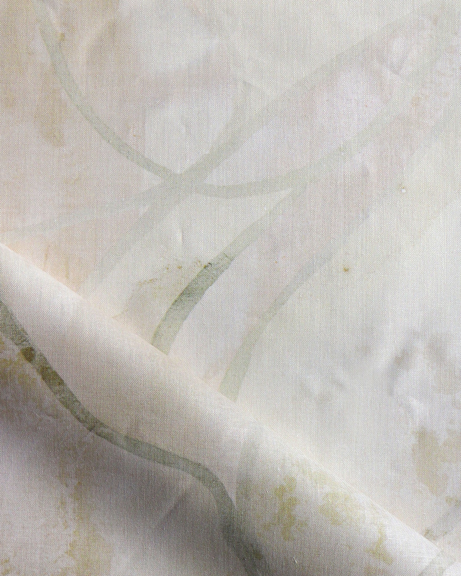 Draped fabric in abstract floral bushstroke design in warm beige. 