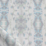 Detail of draped fabric in a painterly gometric stripe in gray, blue and green on a white field.