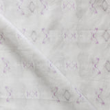 Detail of draped fabric in a striped ink blot print in shades of tan and purple on a cream field.