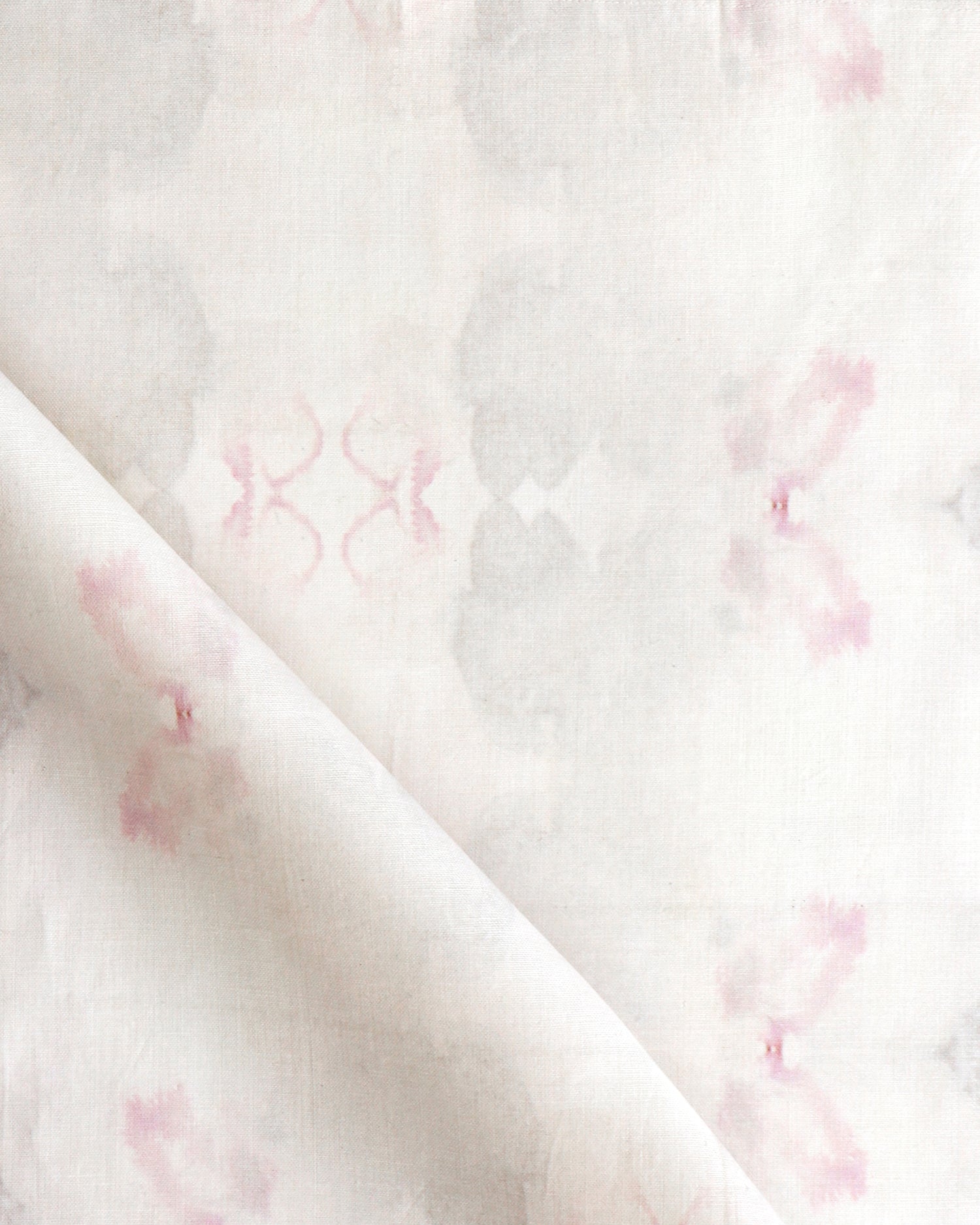 Detail of draped fabric in a striped ink blot print in shades of tan and pink on a cream field.