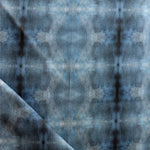 Detail of draped fabric in a repeating ink blot print in navy on a charcoal field.