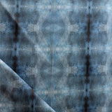 Detail of draped fabric in a repeating ink blot print in navy on a charcoal field.