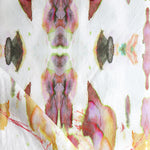 Detail of draped fabric in a watercolor paint blotch print in shades of gray, yellow and pink on a white field.