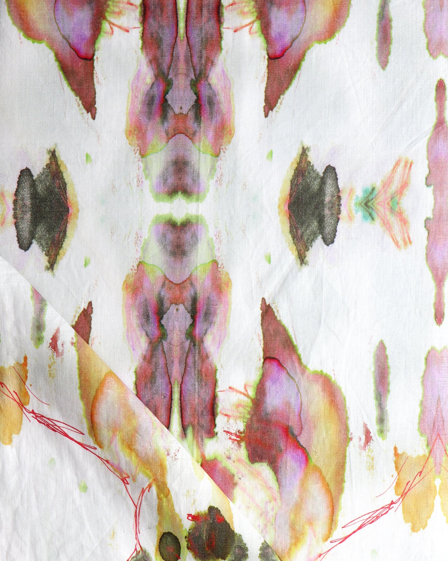 Detail of draped fabric in a watercolor paint blotch print in shades of gray, yellow and pink on a white field.