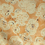 Patterned fabric with lace-like design on an yellow background