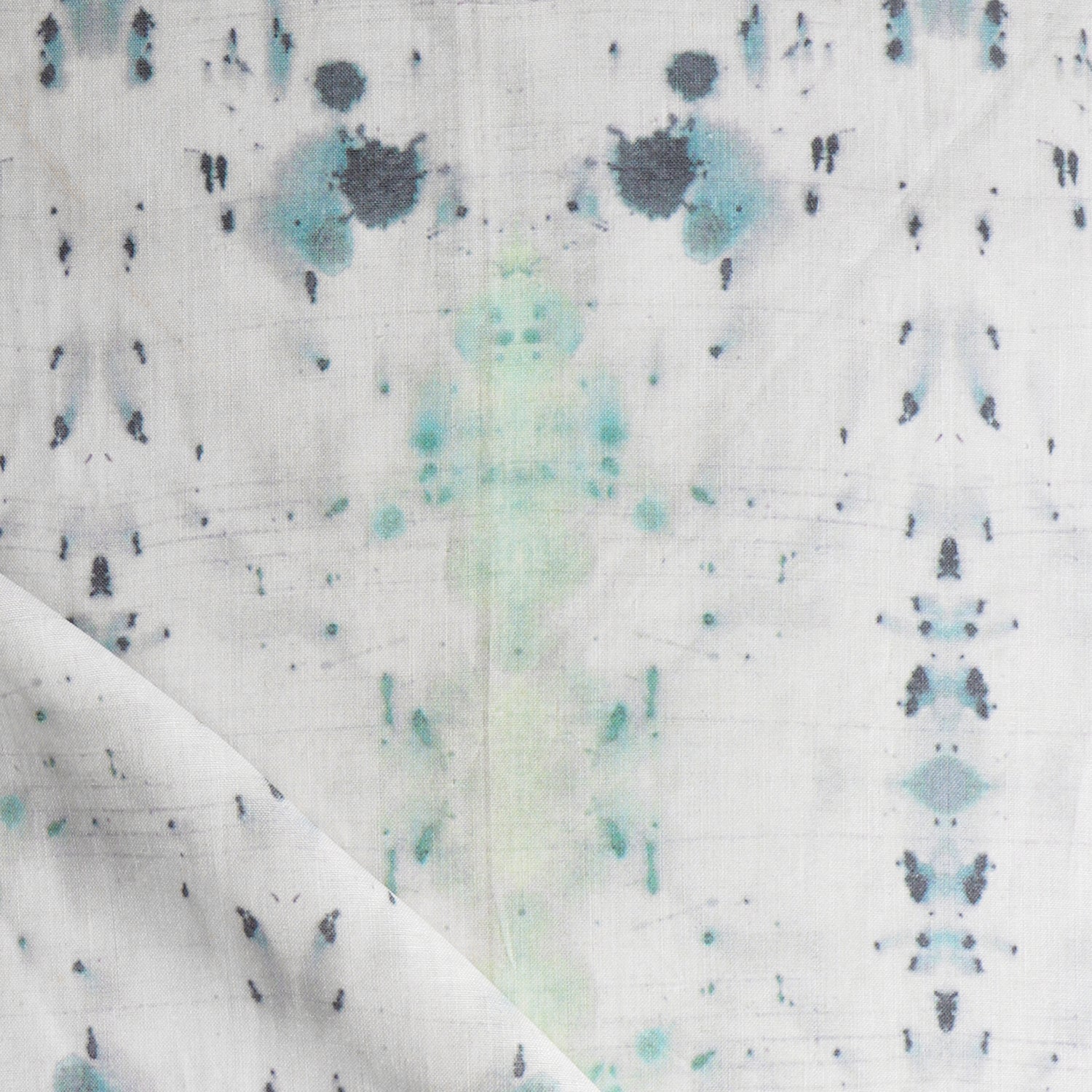 Detail of draped fabric in a watercolor ink blot print in gray and green on a cream field.