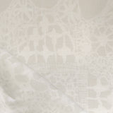 Close-up of a watercolor lace design in soft beige. 