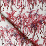 Detail of draped fabric in a painterly palm tree stripe print in shades of pink and red on a white field.