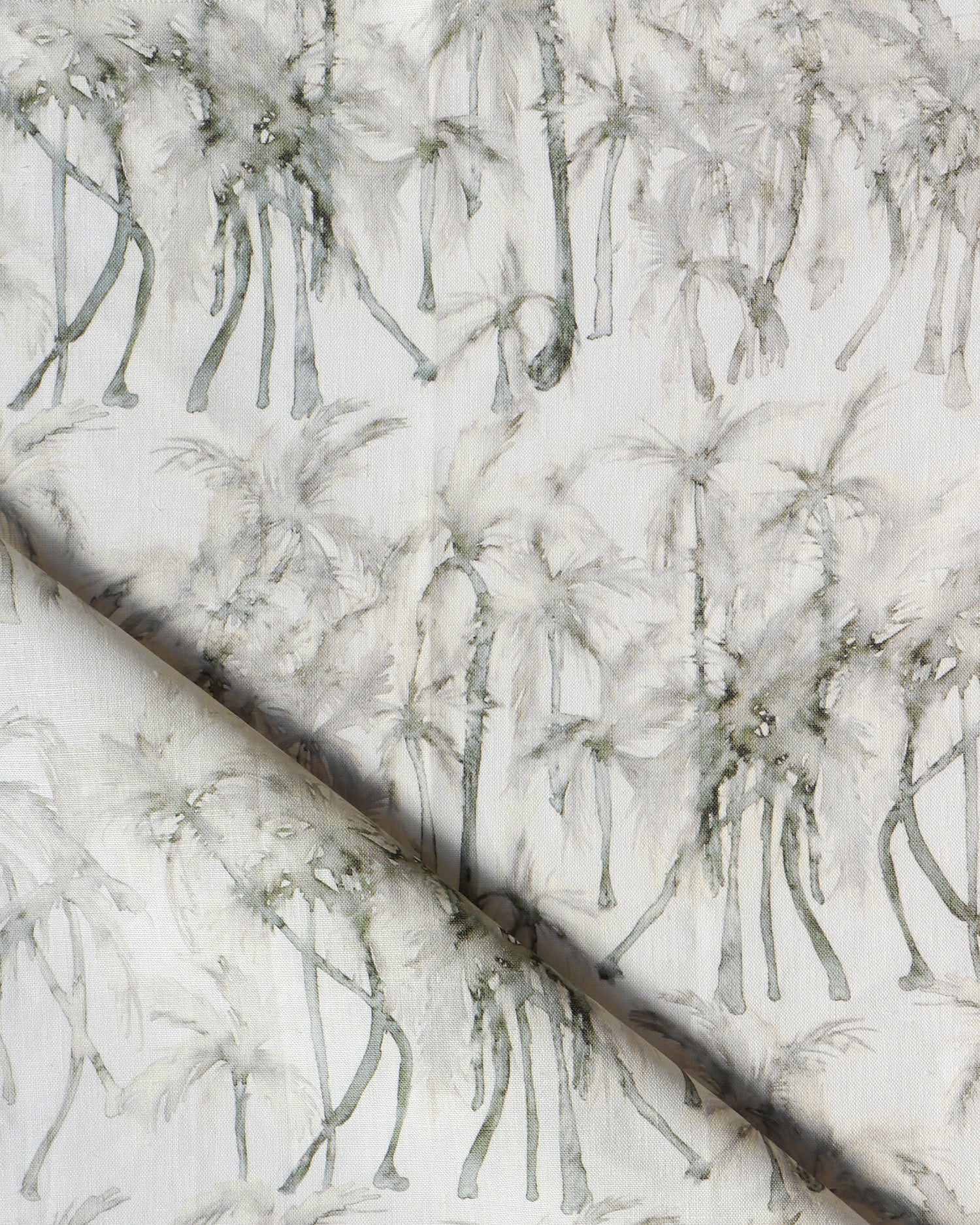 Detail of draped fabric in a painterly palm tree stripe print in shades of cream and gray on a white field.
