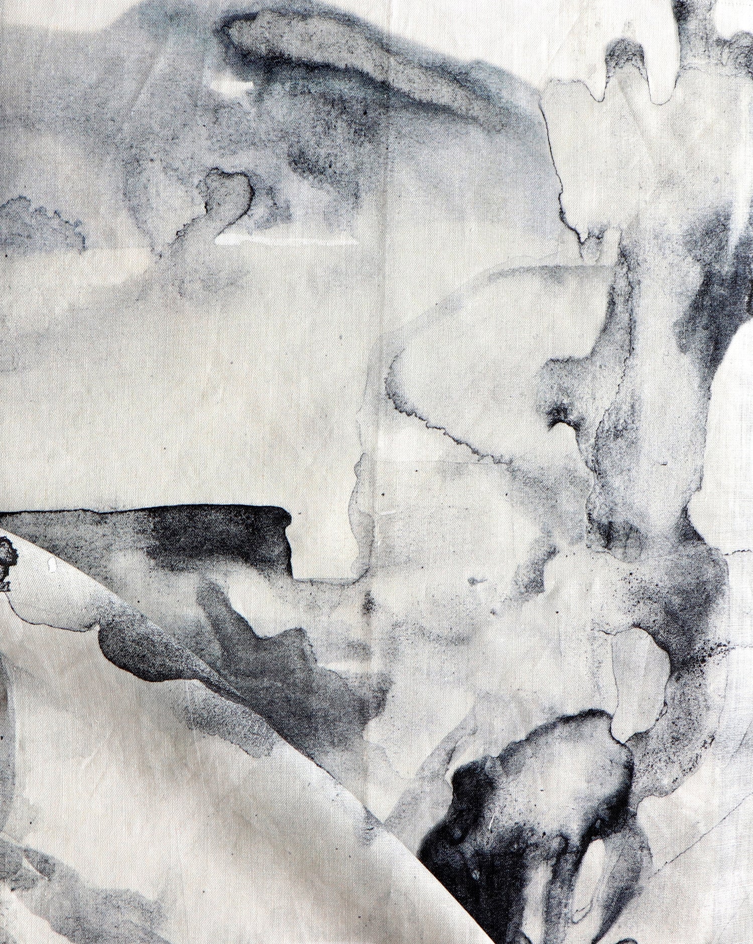 Detail of draped fabric in a watercolor painterly print in shades of gray and white.