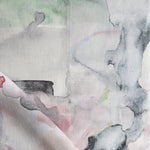 Detail of draped fabric in a watercolor painterly print in shades of pink, gray and white.