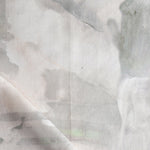 Detail of draped fabric in a watercolor painterly print in shades of gray and cream.