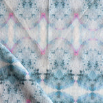 Detail of draped fabric in a watercolor ink blot pattern in shades of gray, blue and pink.