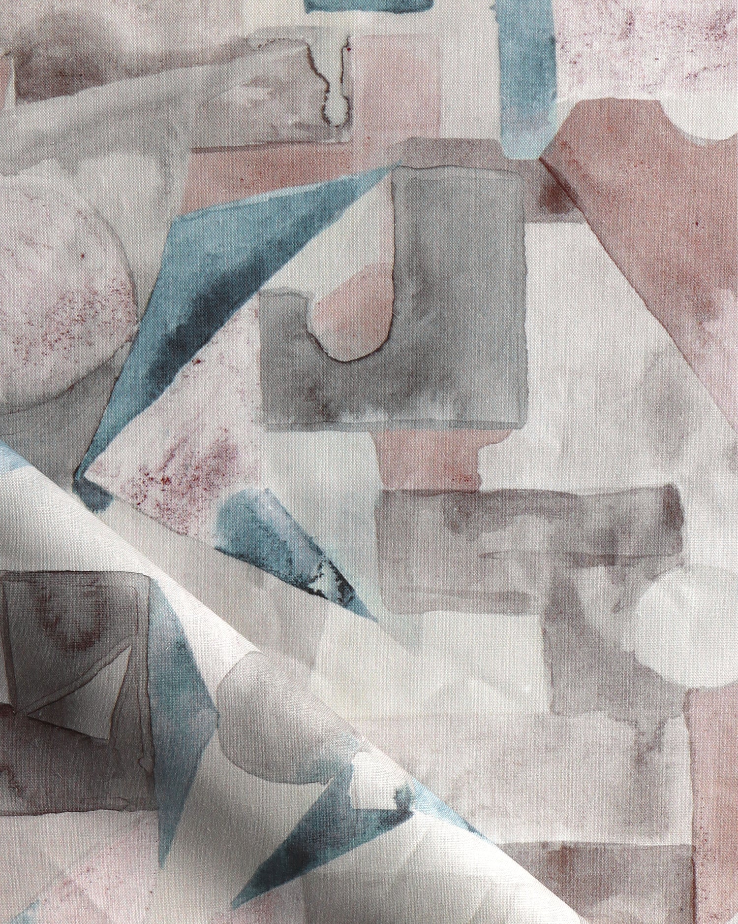 Draped fabric in a geometric puzzle piece watercolor pattern in blush, grey and teal. 