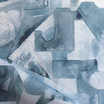 Draped fabric in a geometric puzzle piece watercolor pattern in shandes of slate blue. 