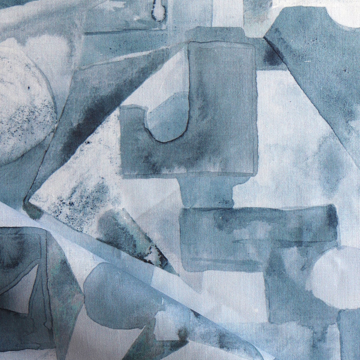 Draped fabric in a geometric puzzle piece watercolor pattern in shandes of slate blue. 