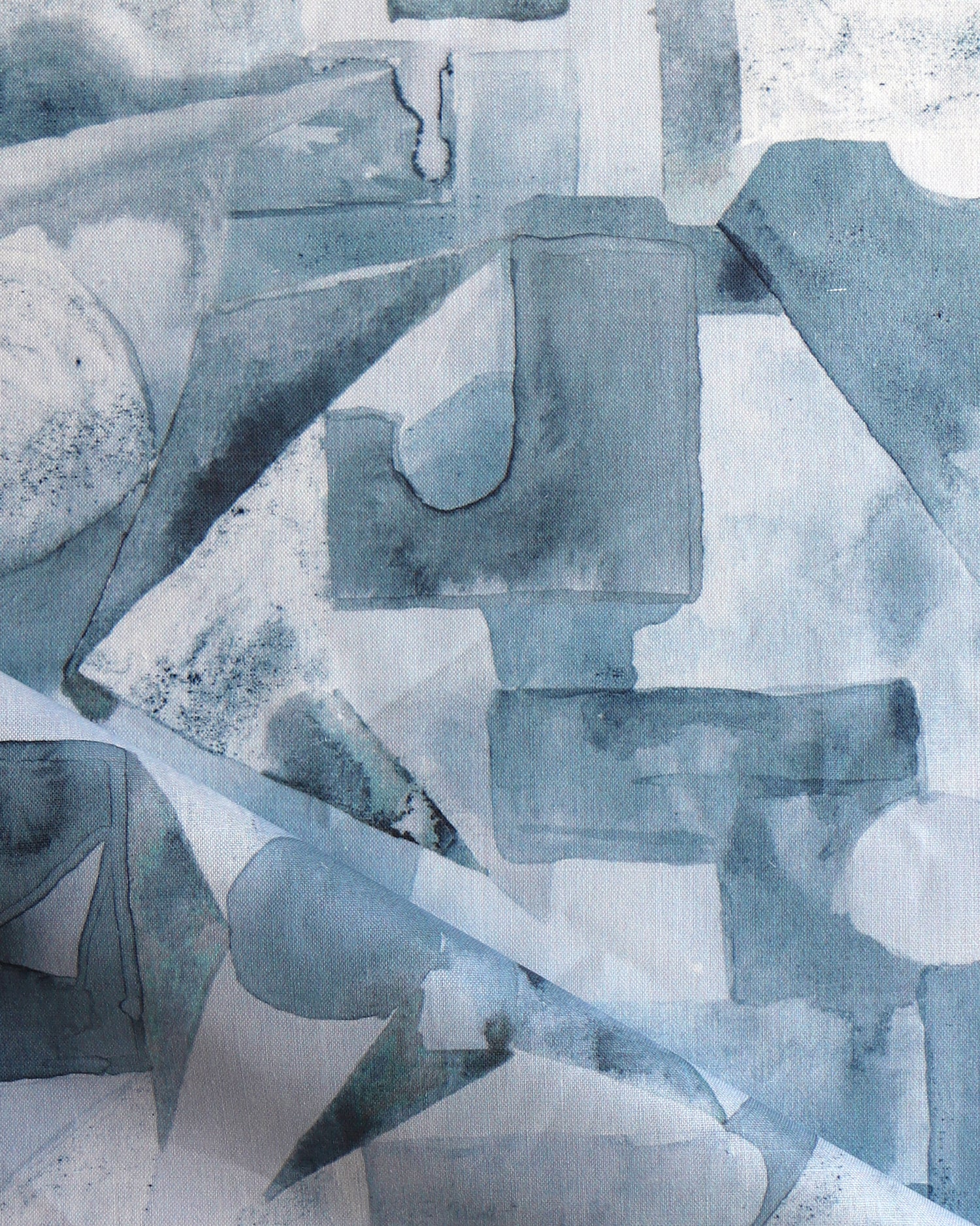 Draped fabric in a geometric puzzle piece watercolor pattern in shandes of slate blue. 