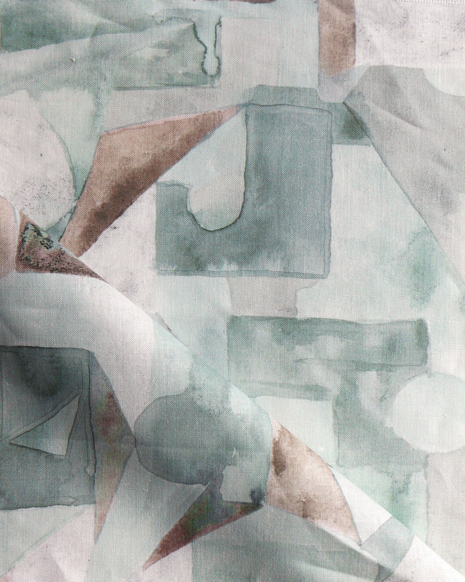 Draped fabric in a geometric puzzle piece watercolor pattern in sage green, grey and brown. 