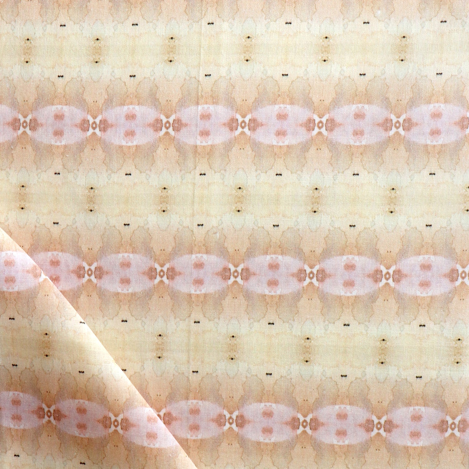 Detail of draped fabric in a gridded paint splatter print in shades of pink, orange, yellow and white.