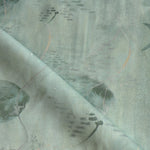 Draped fabric in an watercolor oceanic fish pattern in sage green. 