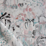 Detail of draped fabric in a painterly tree print in shades of gray, pink and turquoise.