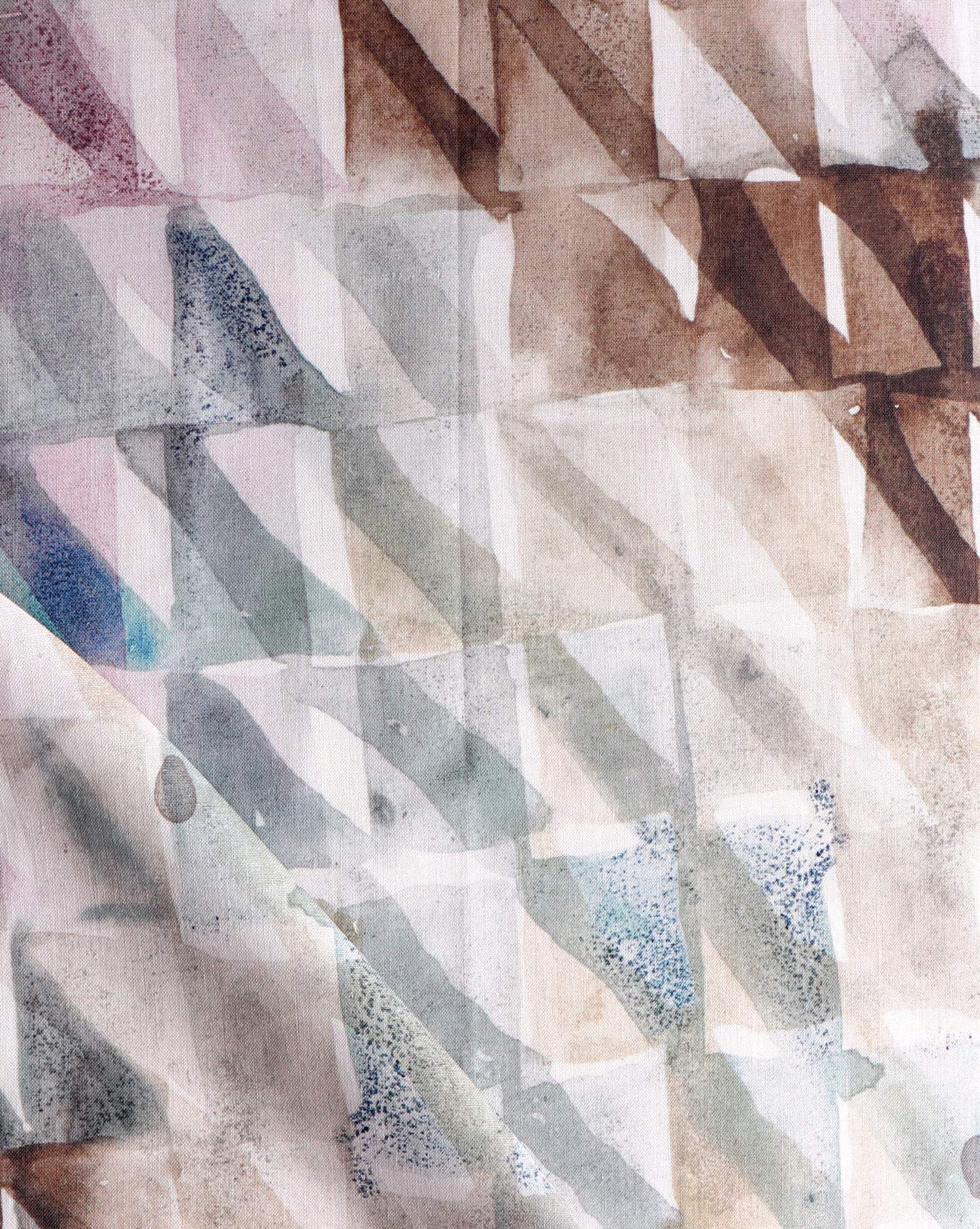 Detail of draped fabric in a painterly check pattern in shades of brown, blue and pink.