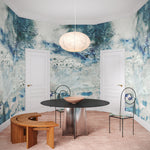 Ornate dining room scene with an ethereal watercolor mural in shades of teal and grey. 