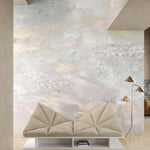 Living room with modernist couch and lamp against ethereal watercolor mural in blush pink, yellow, aqua and grey. 