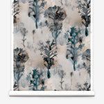 Wallpaper roll in a watercolor tree print in shades of turquoise, gray and gold on a cream field.