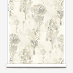 Wallpaper roll in a watercolor tree print in shades of tan and gray on a white field.