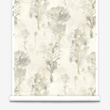 Wallpaper roll in a watercolor tree print in shades of tan and gray on a white field.