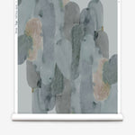 Wallpaper roll in watercolor elongated pill pattern in moody blues and taupe on a white field.