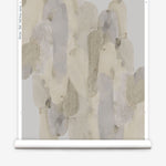 Wallpaper roll in watercolor elongated pill pattern in tan, taupe and grey on a white field.