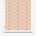 Wallpaper roll in a repeating ink blot print in shades of gray with turquoise and pink accents.
