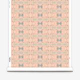 Wallpaper roll in a repeating ink blot print in shades of gray with turquoise and pink accents.