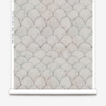 Wallpaper roll in a watercolor linear scallop pattern in navy on a cream field. 