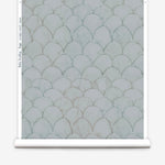 Wallpaper roll in a watercolor linear scallop pattern in green on a sage field. 