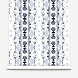 Wallpaper roll in a watercolor ikat stripe print in shades of blue and black on a white field.