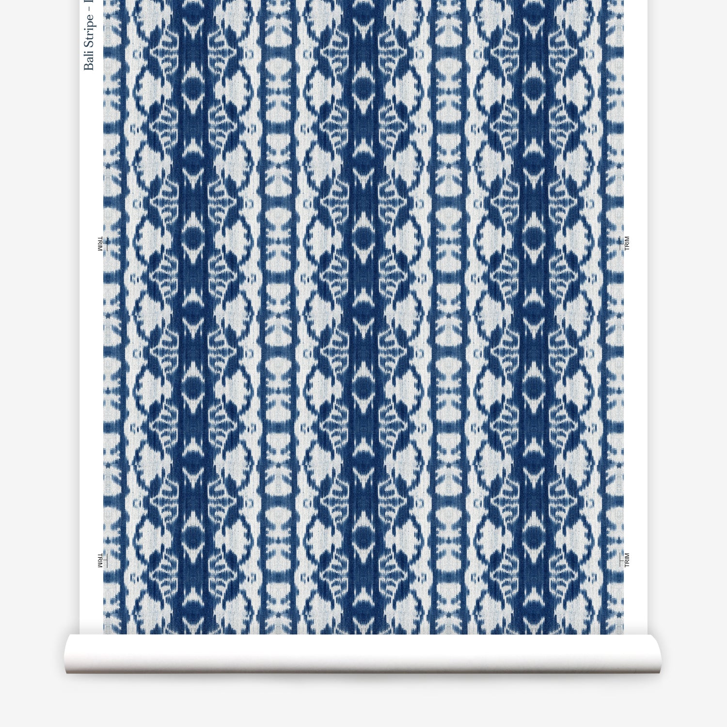 Wallpaper roll in a watercolor ikat stripe print in shades of white and blue on a gray field.
