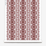 Wallpaper roll in a watercolor ikat stripe print in shades of white on a red field.