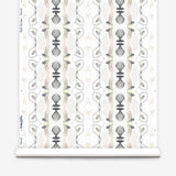 Wallpaper roll in a watercolor ikat stripe print in shades of cream, pink and gray on a white field.