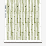 Wallpaper roll in a painterly stripe print in olive on a white field.