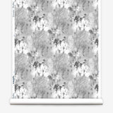 Wallpaper roll in a painterly tree print in gray and charcoal on a white field.